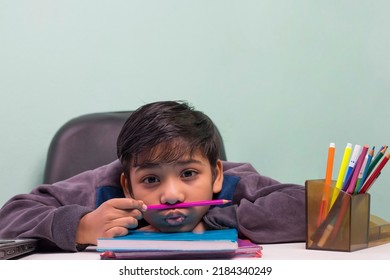 A Boy Holding Pencil Under His Nose