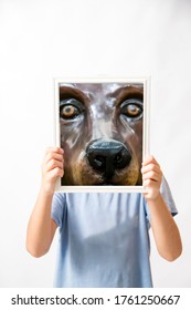 Boy Holding Up A Picture Of A Dog’s Face