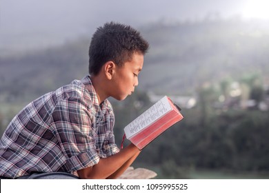 boy holding and reading the scriptures.