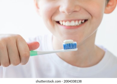 The boy is holding a toothbrush in his hands. Brushing your teeth. Soft focus - Powered by Shutterstock