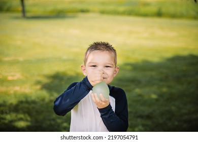 Boy Holding A Water Balloon In The Summer Time