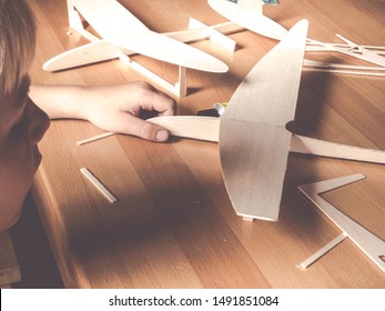 Boy Holding A Wooden Plane Model; Aircraft Construction Made Of Balsa Wood