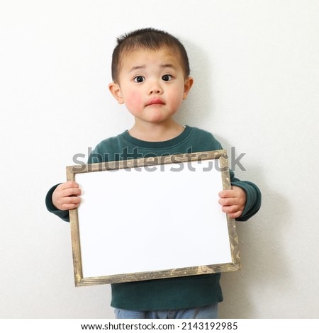 Boy holding writable white paper.