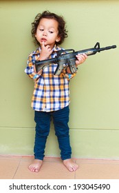 The Boy Holds A Toy Gun