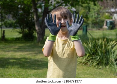 Boy In Home Garden Wearing Gardening Gloves