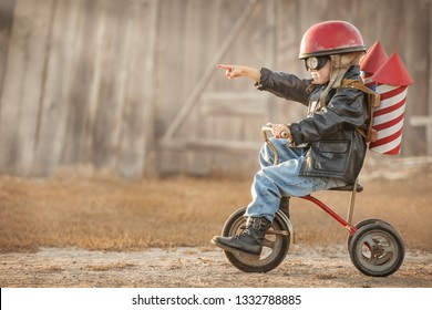 Boy in the image of a rider and a rocketman play in the backyard of the house