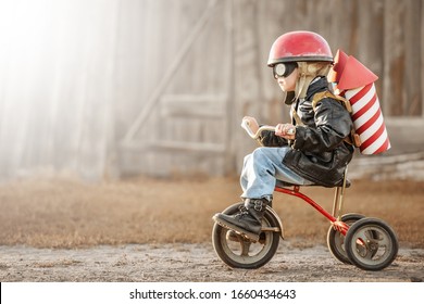 Boy in the image of a rider and a rocketman play in the backyard of the house