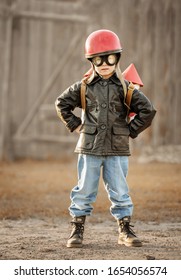 Boy in the image of a rocketman play in the backyard of the house