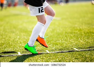 Boy Improving Speed With Ladder Drills On Football Field. Young Soccer Player Training Agility On The Pitch. Soccer Individual Skills Training