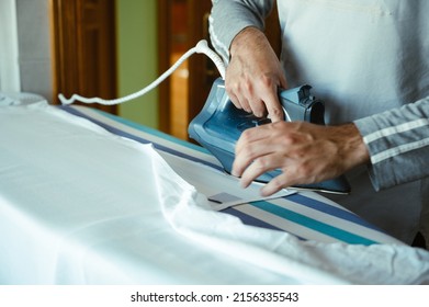 Boy Ironing Sheets At Home