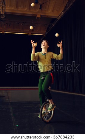 Boy juggling and riding unicycle