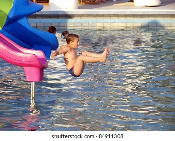 Boy Jumping Into The Water From Toboggan