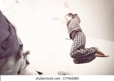 Boy Jumping Onto A Bed