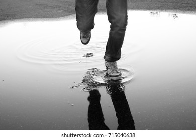 Boy jumping in a puddle