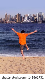 Boy Jumping To The Vancouver From North Vancouver Beach On Summer Holidays.