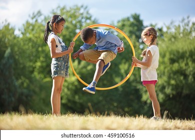 Boy jumps through hula hoop at the park