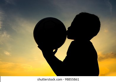 Boy kiss the ball during sunset - Powered by Shutterstock