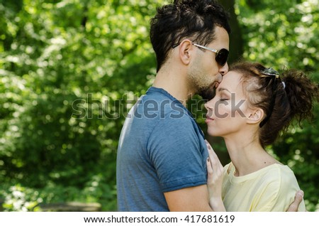 Boy kissing a girl in the head, boy and girl in the woods jelenoj are embracing and kissing