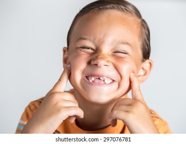 Boy Laughing And Being Goofy Showing His Lost Teeth.