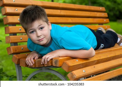 The boy lay on a bench