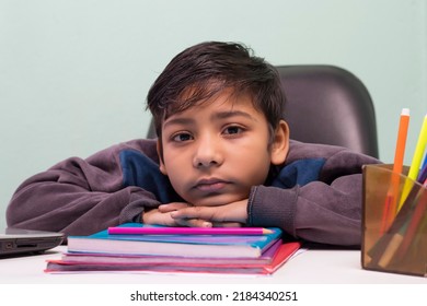 a boy laying down on table and looking at camera
