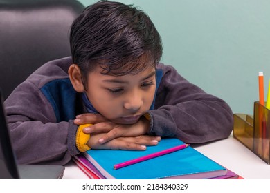 a boy laying down on table and thinking