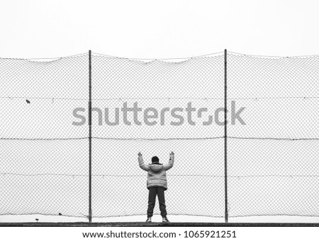 boy leaning on fence