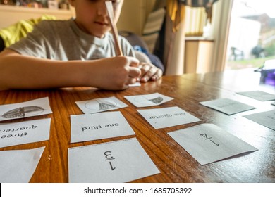 A Boy Is Learning About Fractions At Home Doing Maths Homework Which Has Been Sent During The Coronavirus Pandemic.