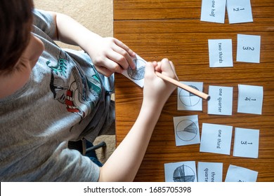 A Boy Is Learning About Fractions At Home Doing Maths Homework Which Has Been Sent During The Coronavirus Pandemic.