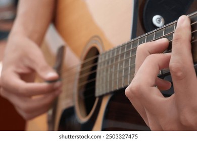 boy learning to play guitar, young guitarist, guitar practice, music lesson, beginner guitarist, teenager with guitar, acoustic guitar, music education, learning an instrument, boy playing  - Powered by Shutterstock