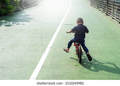 Boy Learning To Ride A Bicycle. The Boy Is Riding A Bike On The Street The Boy Is Riding A Bike On The Street. Bicycle, Child, Sidewalk, Amusement Park Ride, Boys