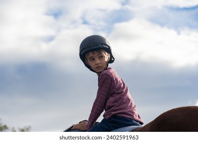 Boy learning to ride a horse - Powered by Shutterstock