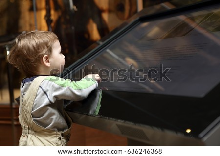Boy learning touch screen in a museum