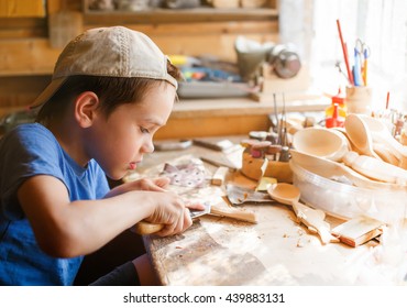 boy learning wood carving. young carpenter working in a workshop