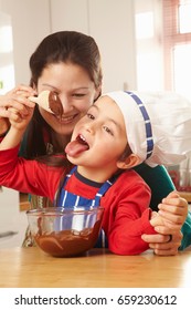 Boy Licking Chocolate Off Spoon With Mum