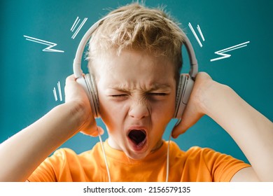 Boy listens to loud music with headphones. Сhild listens to rock music