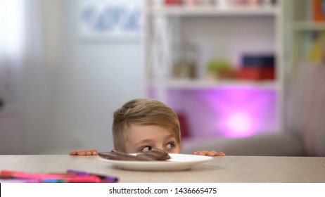 Boy Looking Around From Under Table, Plate With Chocolate, Stealing Sweets