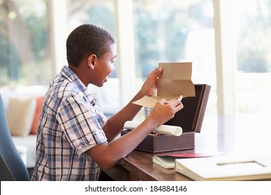 Boy Looking At Letter In Keepsake Box On Desk