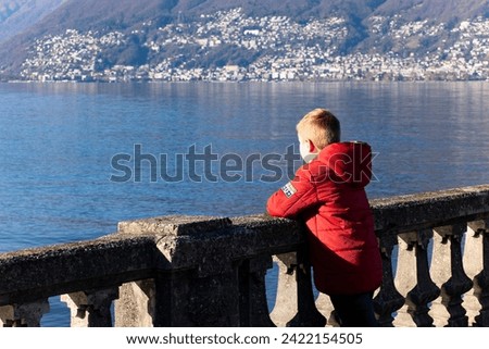 a boy looking out over the water