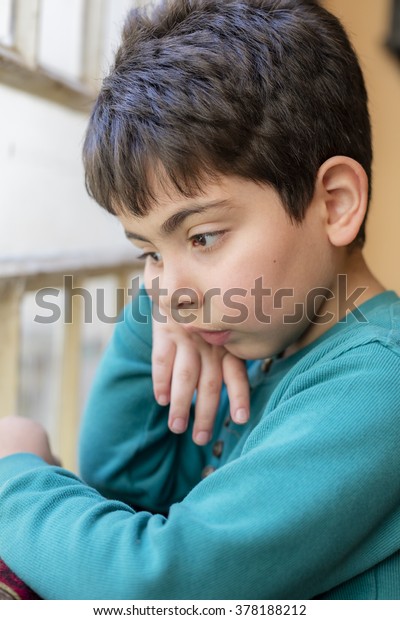 Boy looking
through window inside house in
Iraq