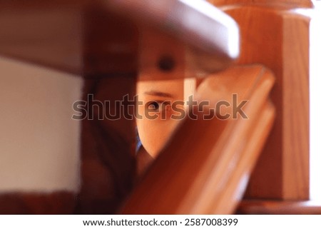 a boy looking through the wooden structure with curiosity, a closeup photo of the young boy's eye in the mysterious setting with lots of light in the daytime