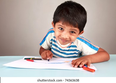 A boy looking while painting on a white paper - Powered by Shutterstock