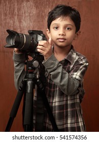 A boy looks through a camera fixed on a tripod