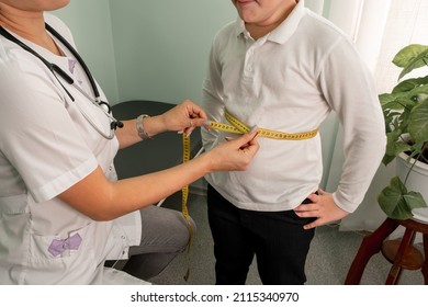 Boy losing excess weight. Nutritionist measuring his waistline. Upset boy during waistline measurement at nutritionists appointment. Female doctor measuring overweight boy in clinic. Childhood obesity
