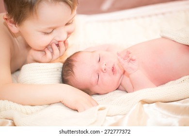 A Boy Is Lovingly Hugging His Newborn Baby Brother.