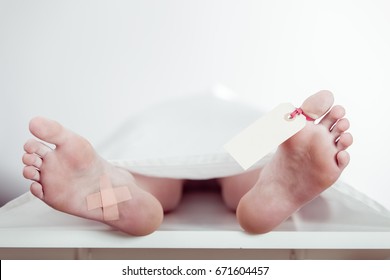 Boy Lying On A Mortuary Slab With A Blank Identification Tag On His Toe And Plaster On The Sole Of His Foot, Close Up To The Feet