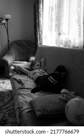 The Boy Is Lying On The Sofa With His Eyes Closed. The Black And White Photo Was Taken In Gomel, Belarus, On July 12, 2022