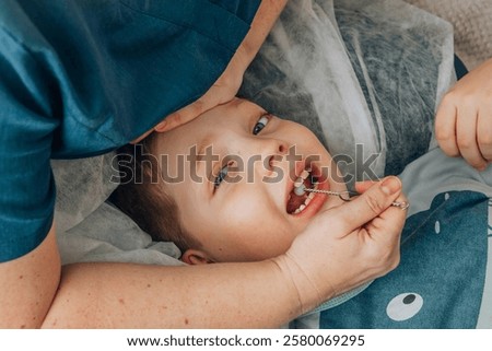 boy lying on soft white blanket during speech therapy session with female therapist in cozy room, concept of speech correction, childhood development, and healthcare, close up