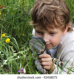 boy with magnifying glass outdoors