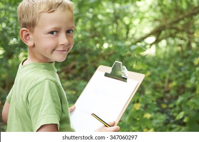 Boy Making Notes On School Nature Field Trip